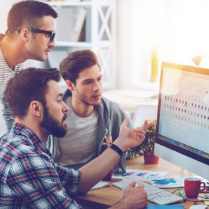 Discussing new project. Three young business people discussing s design services